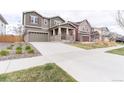 Charming two-story home with a covered front porch, a well-manicured lawn and an attached two-car garage at 5937 N Orleans St, Aurora, CO 80019
