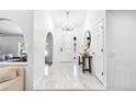Bright foyer with elegant chandelier, white tile flooring, and an arched entryway at 3253 S King Way, Denver, CO 80236