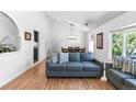 Comfortable living room featuring a large sofa, wood floors, and a dining area at 3253 S King Way, Denver, CO 80236