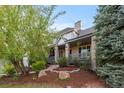 Charming front porch with stone pillars, wood railing, and decorative landscaping creates an inviting entrance at 7071 Turweston Ln, Castle Pines, CO 80108