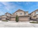 Inviting townhouse exterior featuring stone accents and multiple garages at 14902 E Poundstone Dr, Aurora, CO 80015