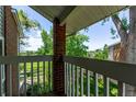 Balcony view featuring a white railing, brick column, and lush greenery at 12183 W Chenango Dr, Morrison, CO 80465