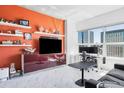 Bright living room offering city views, a dedicated workspace, and an entertainment center with shelving at 891 14Th St # 2816, Denver, CO 80202