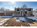 Gray two-story home with attached garage, covered porch, and walkway, surrounded by a winter landscape at 15716 E Temple Pl, Aurora, CO 80015