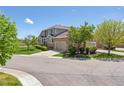View of a well-maintained home with a landscaped yard in a neighborhood with mature trees at 22455 E Plymouth Cir, Aurora, CO 80016