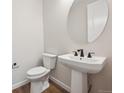 Half bathroom featuring a pedestal sink, stylish dark fixtures, and modern finishes at 5583 Riverbend Ave, Firestone, CO 80504