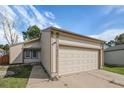 Charming home exterior showcases a two-car garage, well-maintained lawn, and cozy curb appeal at 7834 S Windermere Cir, Littleton, CO 80120
