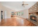 Spacious living room with hardwood floors, stone fireplace, and plenty of natural light at 7834 S Windermere Cir, Littleton, CO 80120