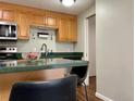 Kitchen with wooden cabinets and hardware, stainless steel appliances, and a peninsula with seating at 2500 S York St # 116, Denver, CO 80210