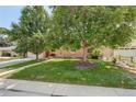 Single-story home featuring a well-maintained lawn, mature trees, and tidy landscaping at 2920 S York St, Denver, CO 80210