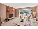 Cozy living room features a brick fireplace, large bay window, and neutral-toned furnishings at 2920 S York St, Denver, CO 80210