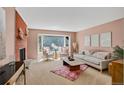 Bright living room with a brick fireplace, comfortable seating, and abundant natural light at 2920 S York St, Denver, CO 80210