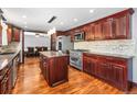 Well-appointed kitchen with stylish cabinetry, stainless steel appliances, a granite island, and hardwood floors, creating a modern aesthetic at 140 Lane Ct, Fort Lupton, CO 80621