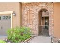 Attractive front entrance features a brick archway with a gate, adjacent garage, and manicured landscaping at 9218 Viaggio Way, Highlands Ranch, CO 80126