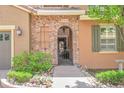 The home features a unique stone archway entrance, charming light fixture and lush, well-maintained landscaping at 9218 Viaggio Way, Highlands Ranch, CO 80126