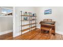 Bright living room showcasing stylish shelving, a piano, and gleaming hardwood floors at 4440 W Hayward Pl, Denver, CO 80212