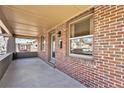 Close-up of a brick porch featuring a covered ceiling, door, and window views at 4440 W Hayward Pl, Denver, CO 80212