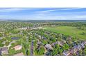 Expansive aerial view of a neighborhood with lush greenery and a pond at 5746 Aspen Creek Dr, Broomfield, CO 80020