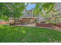 A large backyard featuring mature trees, a stone grill and outdoor dining and seating area at 5746 Aspen Creek Dr, Broomfield, CO 80020