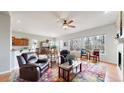 Bright living room with a colorful rug, wood floors, and a cozy seating area with large windows at 16500 Crosby Dr, Broomfield, CO 80023