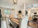 Elegant dining room featuring tufted chairs, a modern light fixture, and seamless transition to the living area at 6346 Fenton St, Arvada, CO 80003