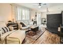 Inviting living room with hardwood floors, a comfortable sofa, decorative rug, and a striking black brick fireplace at 6346 Fenton St, Arvada, CO 80003