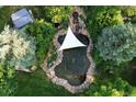 Relaxing koi pond with shade sail, surrounded by lush landscaping at 12768 Grizzly Dr, Littleton, CO 80127