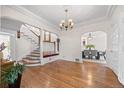 Bright living room with hardwood floors, staircase, decorative chandelier, and elegant archway at 963 N Lafayette St, Denver, CO 80218