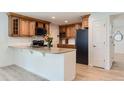 Well-equipped kitchen featuring an island with granite countertops, wooden cabinets, and modern appliances at 7946 S Pennsylvania Ct, Littleton, CO 80122