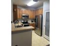 Well-lit kitchen with stainless steel appliances and ample cabinet space and a pantry at 10457 W Hampden Ave # 104, Lakewood, CO 80227