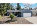 Attractive blue home with manicured landscaping and a paved driveway at 3064 S Holly Pl, Denver, CO 80222