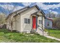 Charming bungalow-style home with a red front door, black trim, and green lawn at 1746 Galena St, Aurora, CO 80010