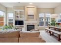 Bright living room featuring a fireplace, built-in shelving, and large windows with natural light at 9580 E 5Th Ave, Denver, CO 80230