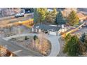 Aerial view of the home showcasing the roof, circular driveway, and mature trees at 9783 Zephyr Dr, Broomfield, CO 80021