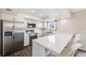 Modern kitchen features stainless steel appliances, white cabinets, a breakfast bar, and recessed lighting at 3964 S Yosemite St, Denver, CO 80237