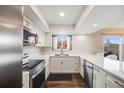 Bright kitchen with white cabinetry, stainless steel appliances, and a view to the patio at 3964 S Yosemite St, Denver, CO 80237