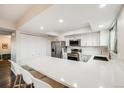 Bright kitchen with white cabinetry, stainless steel appliances, and a large counter at 3964 S Yosemite St, Denver, CO 80237