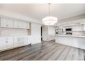 An open-concept living room with light gray floors transitions seamlessly into the modern, all-white kitchen at 3964 S Yosemite St, Denver, CO 80237