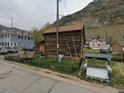 Charming log cabin home with a rustic facade, nestled near scenic mountain views and surrounding dwellings at 605 Argentine St, Georgetown, CO 80444