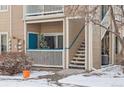Inviting ground floor townhouse entrance with a small porch decorated with a festive Christmas tree at 3847 Mossy Rock Dr # 104, Highlands Ranch, CO 80126