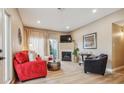 Comfortable living room with a fireplace, neutral walls, wood-look floors, and lots of natural light at 3847 Mossy Rock Dr # 104, Highlands Ranch, CO 80126