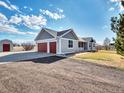 Spacious home features a convenient two-car garage and a gravel driveway at 56450 E 40Th Ave, Strasburg, CO 80136