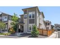 Contemporary gray home featuring stone accents, a small front yard, and modern architectural details at 6700 Clay St, Denver, CO 80221