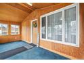 Enclosed sunroom with wood paneling, natural light, and carpeted floor at 276 N 5Th Ave, Brighton, CO 80601