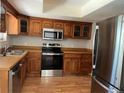 Kitchen featuring stainless steel appliances, wood cabinets, and laminate countertops at 12252 Elmendorf Pl, Denver, CO 80239