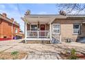 Charming brick home featuring a red front door and covered porch with white railings at 1847 W 41St Ave, Denver, CO 80211