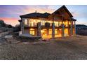 An exterior rear elevation of a luxury home featuring a large covered porch with stone columns at 2208 Stevens Ct, Castle Rock, CO 80109