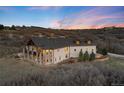 Exterior elevation with stone porch, large windows, and well-maintained landscaping at twilight at 2208 Stevens Ct, Castle Rock, CO 80109