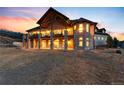 The rear of the luxury home is elevated with a stone porch and outdoor seating area at 2208 Stevens Ct, Castle Rock, CO 80109