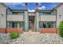 Inviting multi-story condo building with stone walkway, private patios, and light teal and brown exterior paint at 12023 E Harvard Ave # 203, Aurora, CO 80014